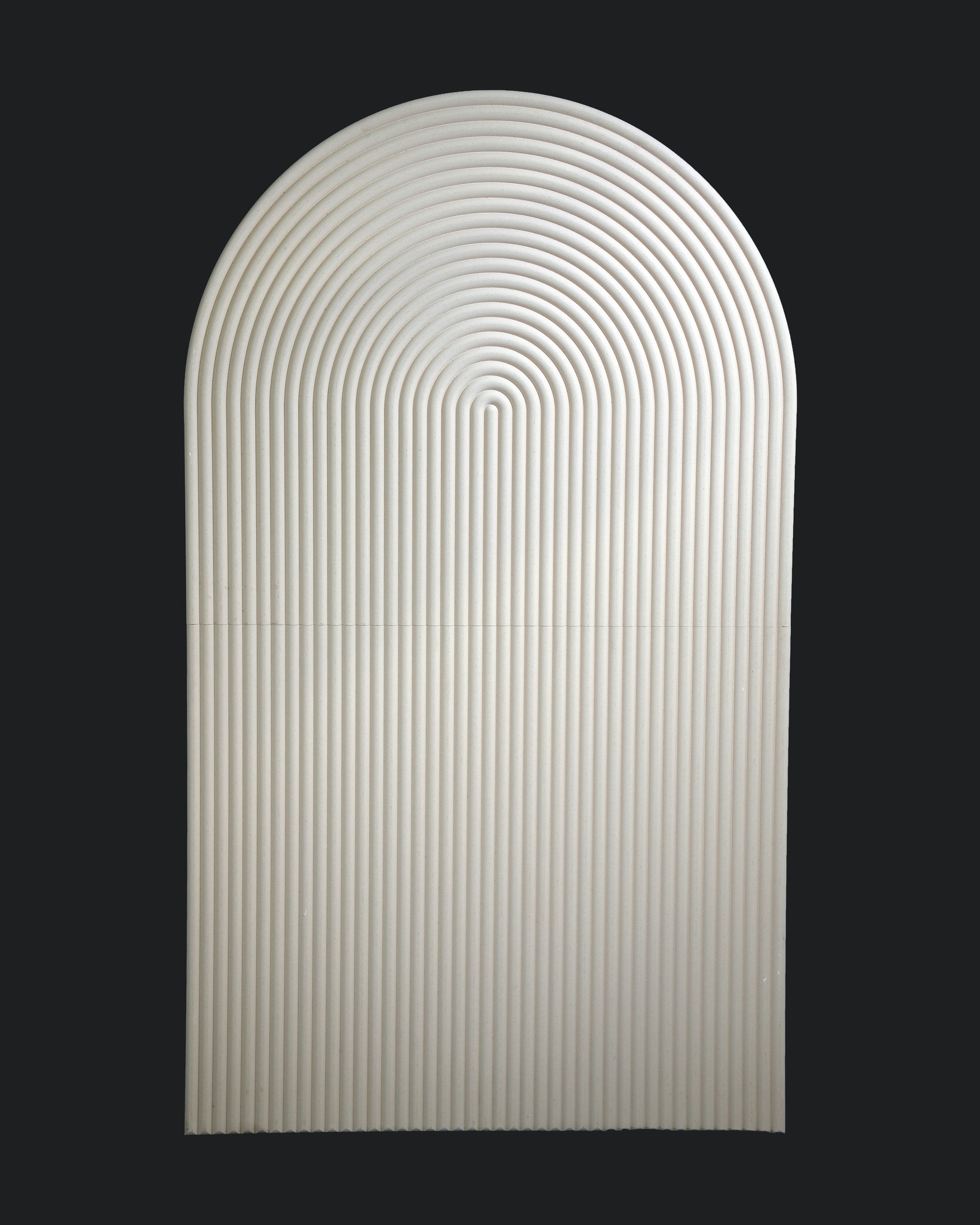A smooth, oval-shaped backdrop with a rippled design, predominantly white in color against a black background.